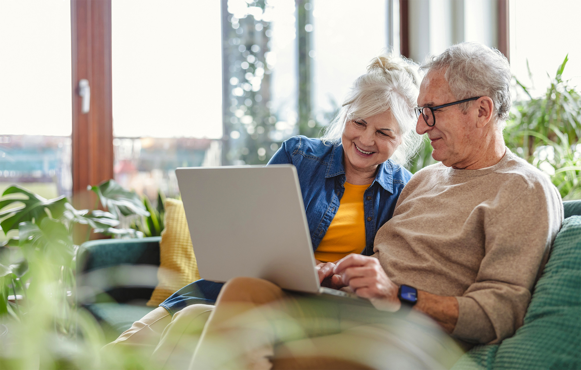 Elderly couple on couch with computer