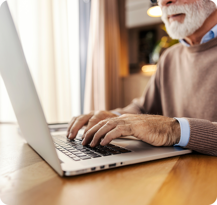 Older gentleman using his laptop on a desk