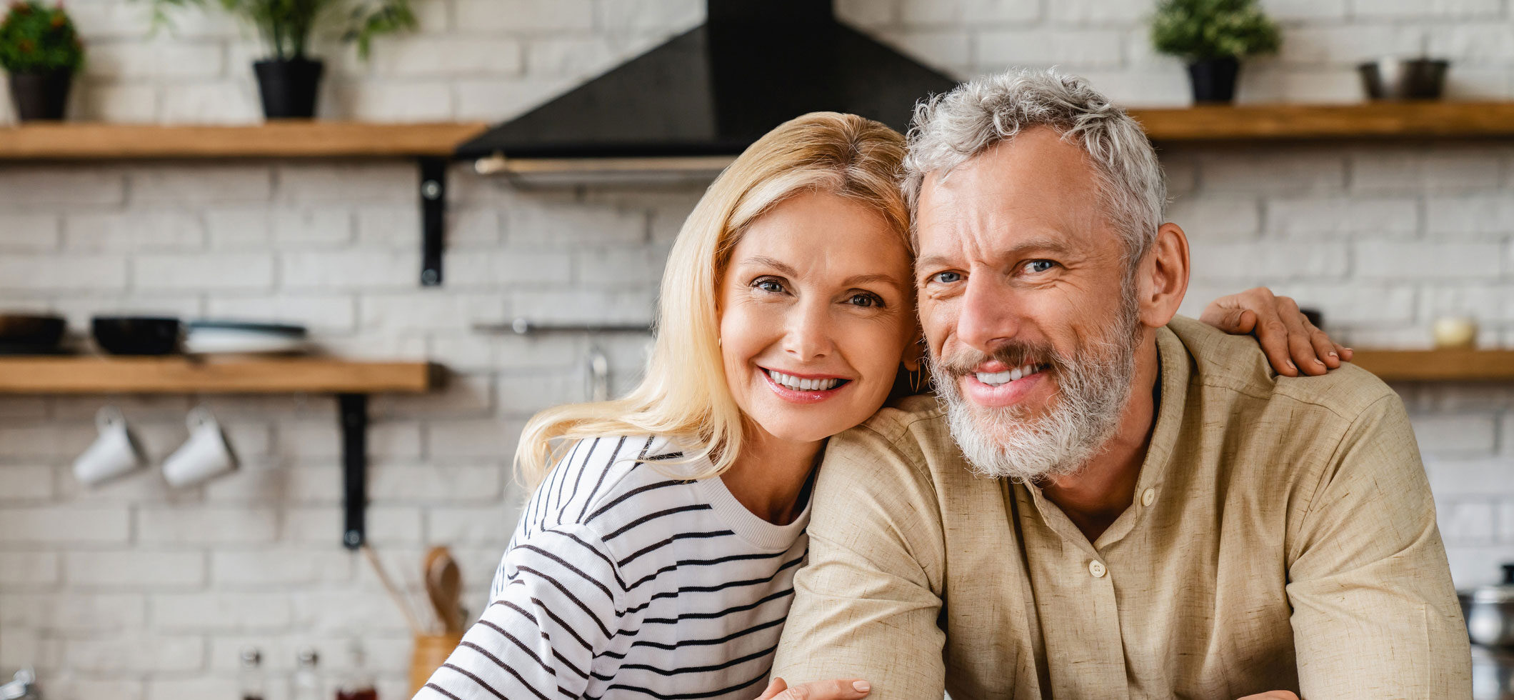 Couple sitting in kitchen smiling