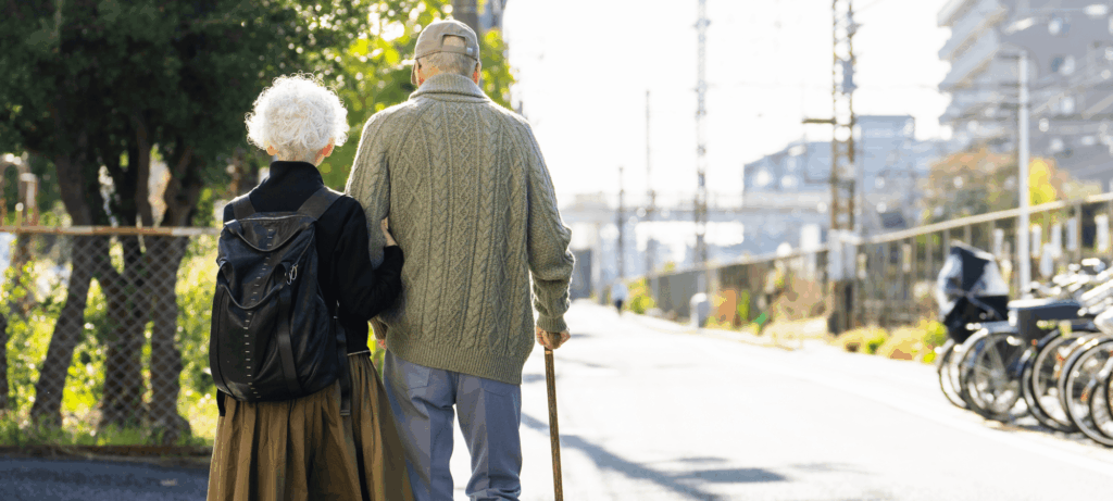Older adult couple walking arm in arm.